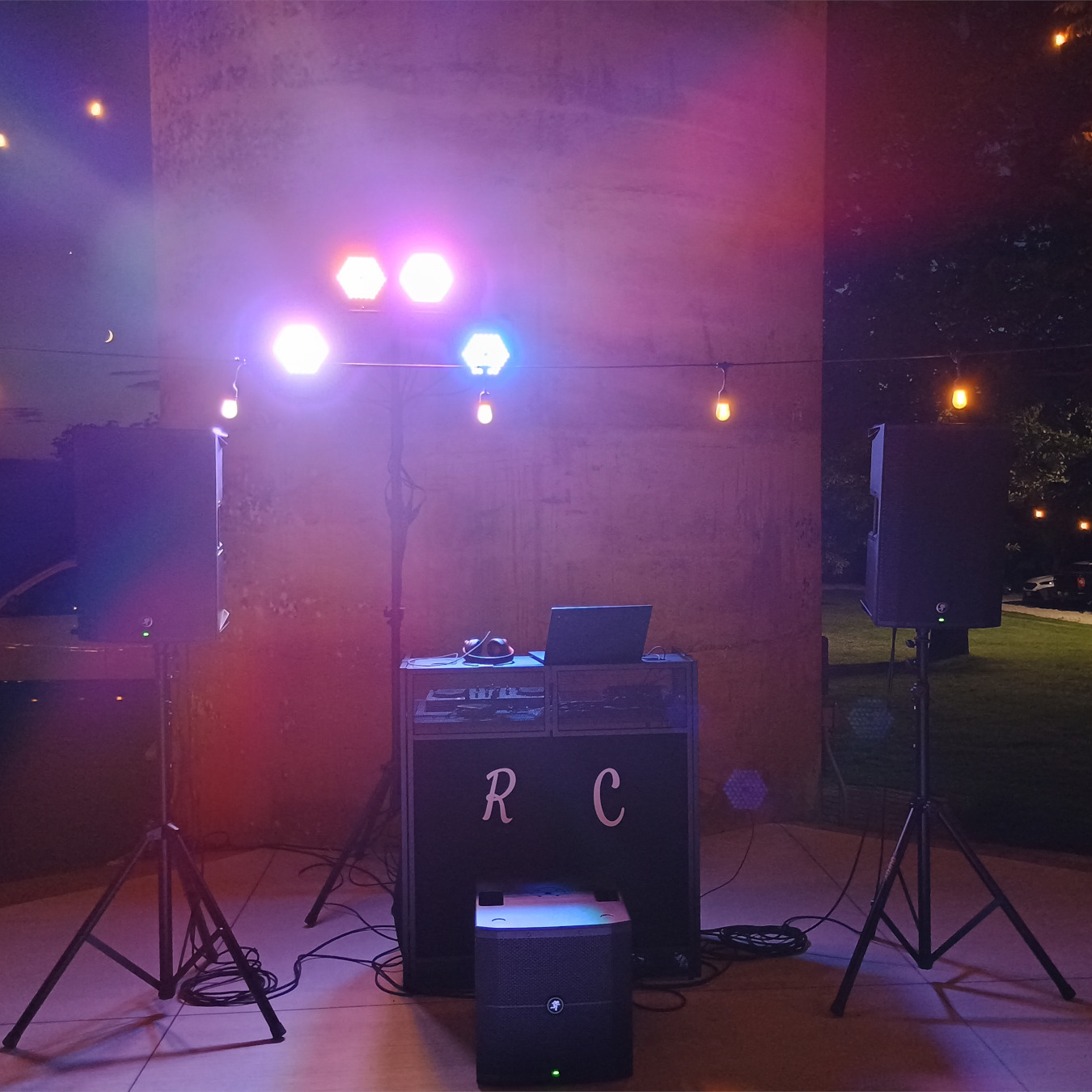 DJ setup with booth, subwoofer, and tops.